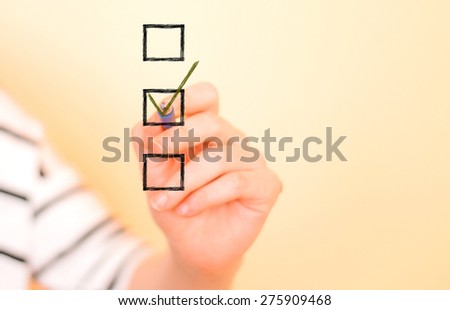 Hand putting check mark with pen