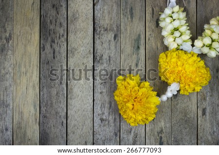 marigold flower garland on wood plank, top view
