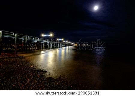 White rock pier at night with reflections on the water