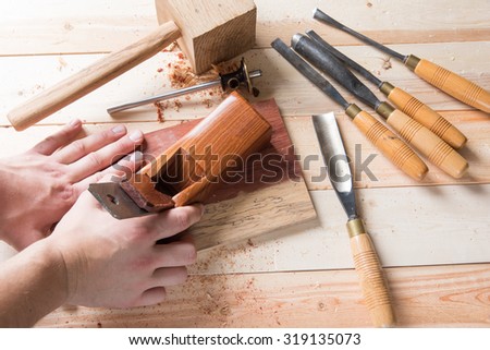 Man using wooden hand plane to smooth wood