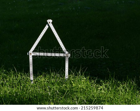 Dream of home ownership, folding rule house symbol, meadow, lawn