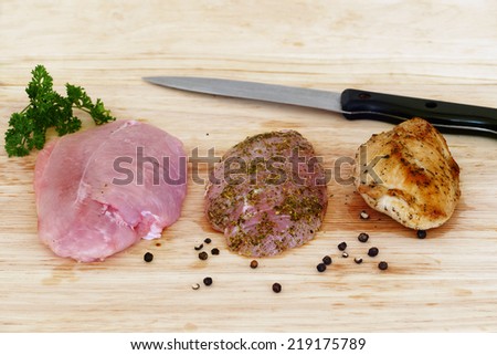 three times poultry meat during preparation, raw, marinated and roasted on a wooden board