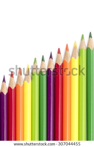crayons or colored pencils in a diagonal row isolated on a white background with copy space, vertical