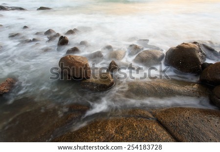 Motion of bubble wave on stone at sunset time. Seascape