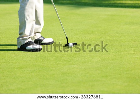 Golf player putting golf ball. Putting golf short. Outdoor sport.