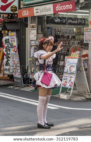 TOKYO, JAPAN - AUGUST 7:  A Japanese girl trying to entice people into maid cafe in Akihabara shown on August 7, 2015 in Tokyo, Japan