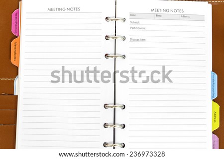 brown leather notebook cover and gold pen on white background
