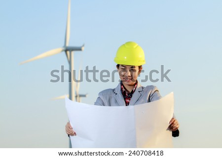 portrait women asia engineer working and holding blueprints at wind turbine farm Power Generator Station
