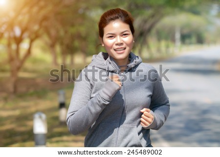 Running woman. Female runner jogging during outdoor  on road .Young mixed race girl jogging in fall colors.