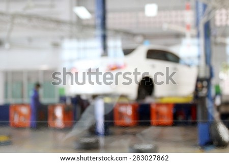 blurry cars on lifts in small service station for background