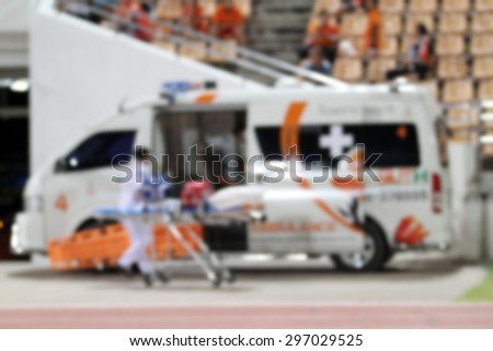 blurry ambulance car stand by at football stadium for help