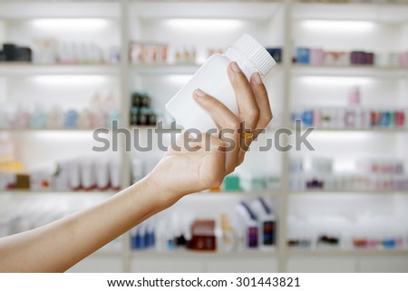 hand of doctor holding medicine bottle on  medicine cabinet and store medicine and pharmacy drugstore