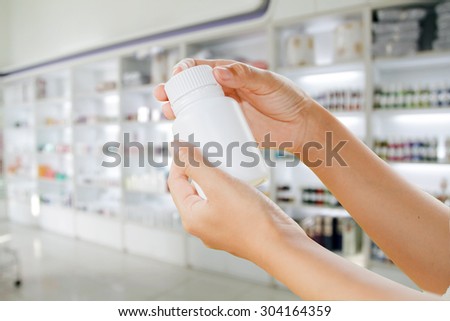 hand of doctor holding medicine bottle on medicine cabinet and store medicine and pharmacy drugstore