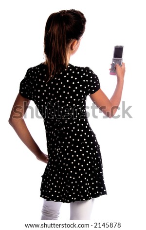 over the shoulder view of a teen age girls hands holding a cell phone as she text messages a friend