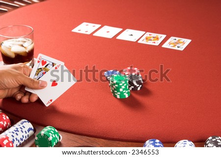 Close up detail of a player looking at his hole cards while playing Texas Hold um poker.Player has a full house Aces over Queens