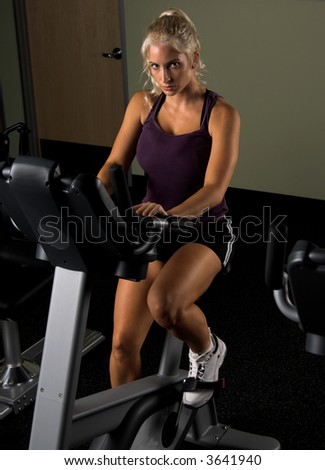 Beautiful blond woman during a cardio workout on an exercise bike in the gym