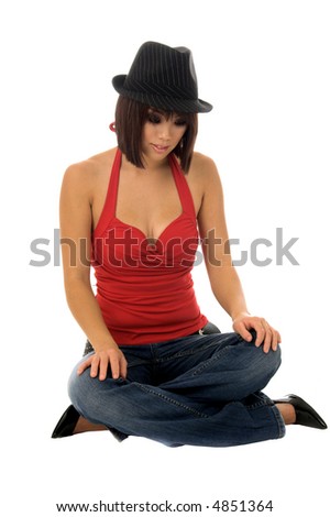Beautiful young Asian model in red blouse and jaunty fedora sitting cross legged on the floor
