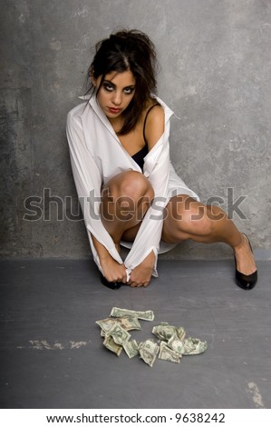 Young woman in a white mans shirt and black lingerie. Sitting on the floor looking dazed, hung over and wrecked after a party binge