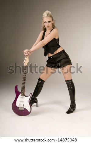 Pretty blonde in black shorts, pinstripe and lace vest and thigh high boots with a purple electric guitar