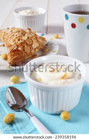 Tasty breakfast: yogurt, bun with ground almonds  and cup of tea