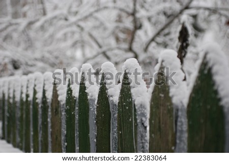 Old wooden fence under the snow