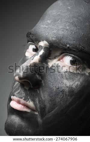 A bald man looking at camera with black paint all over it