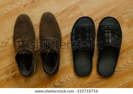 Brown man shoes and slipper on the home wooden floor