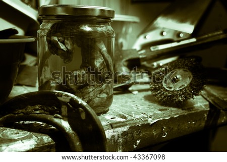 alien embryo in a jar on work bench with tools