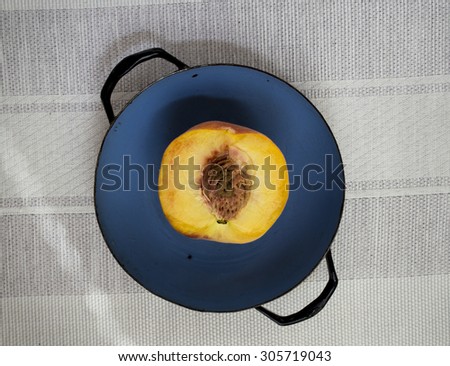 One half of peach in blue pan