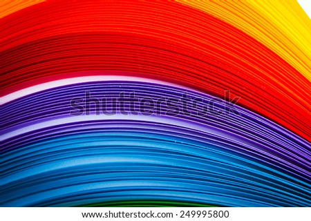 Rainbow colored quilling paper laid out in waves and shapes