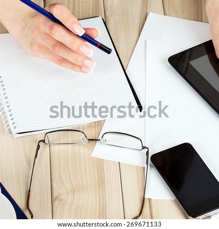 business, education, people and technology concept - close up of female hands, tablet black blank screen with paper, and eyeglasses