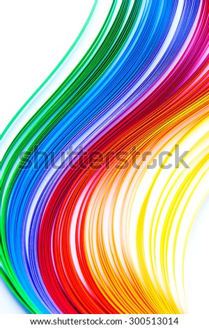 Rainbow colored paper quilling laid in waves isolated on white background