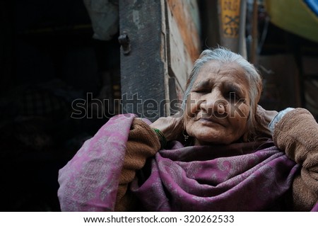 OLD DELHI, INDIA - FEB 15 : Unidentified an old Indian lady sitting at in front of his house at Chandi Chowk street with her traditional clothes, Old Delhi, India on February 15, 2015.
