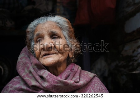 OLD DELHI, INDIA - FEB 15 : Unidentified an old Indian lady sitting at in front of his house at Chandi Chowk street with her traditional clothes, Old Delhi, India on February 15, 2015.