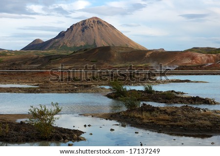 Volcano cone reflected in water of lake in the north of Iceland