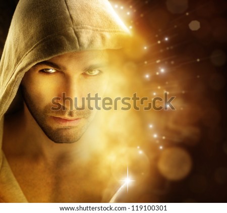 Fantastical portrait of a handsome hero type man in hooded garment in dazzling background with rays of light