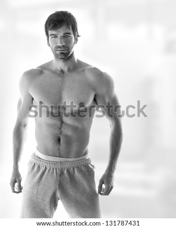 Sexy portrait of a very muscular hot shirtless male model in in sweatpants with copy space