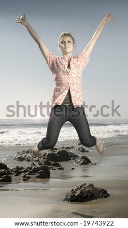 Hip young female model jumping in midair on beach