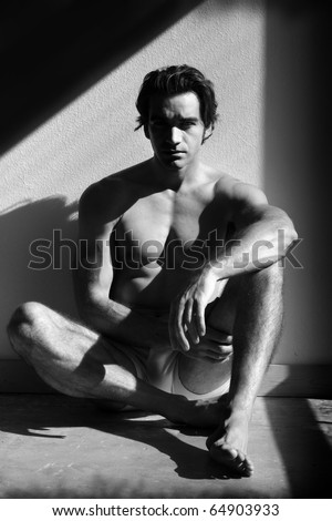 Fine art black and white sensual photo of a young man in underwear