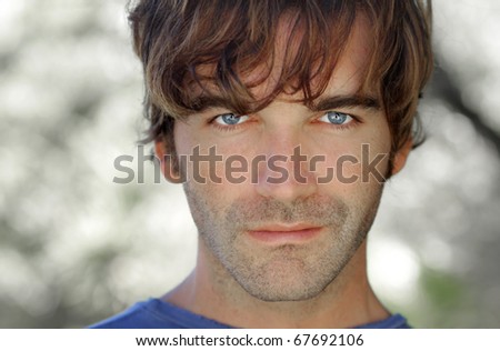 Close-up portrait of young serious man outdoors