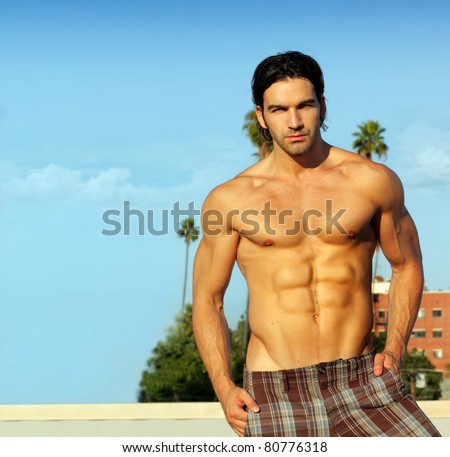 Portrait of a hunky shirtless male model outdoors