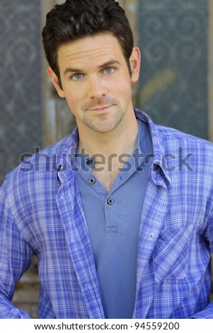Portrait of a happy relaxed young man in blue shirt