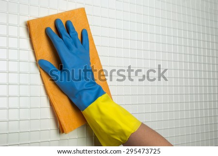orange cloth to clean with a hand in blue with yellow glove on the white cells