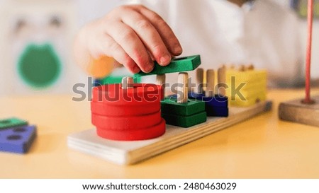 Similar – Image, Stock Photo Toddler playing with a colorful plastic bug toy; using hands to manipulate small object developmental milestone