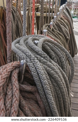 Mast, sail ropes and belaying pins on the deck of the a Tall Ship sailing vessel.