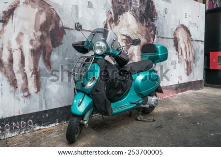 LONDON, UK - OCTOBER 11,2014 : Scooter parked in front of street art graffiti in the Brick Lane area of central London.