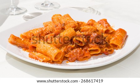 Amatriciana: traditional italian pasta with pork cheek and tomato sauce served with grated cheese