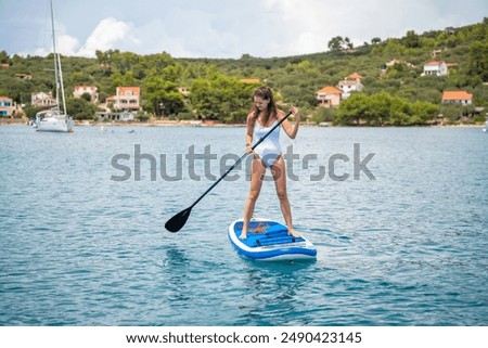 Similar – Image, Stock Photo Woman floating on paddleboard in lake