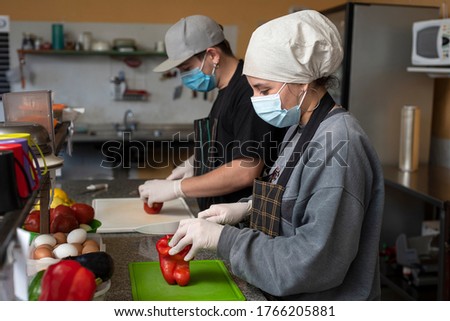 
two young entrepreneurs cooking and handling food with chinstrap and gloves for precaution Foto stock © 