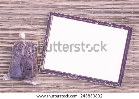 wooden old black picture frame on traditional mat with white space in the middle with shrimp paste in plastic bag, vintage filter
